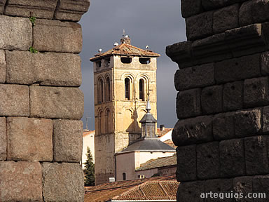 La torre campanario de la iglesia de los Santos Justo y Pastor  vista a traves de los huecos de los arcos del Acueducto de Segovia
