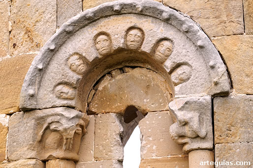 Ventanal de la cabecera con una arquivolta que lleva cabecitas humanas