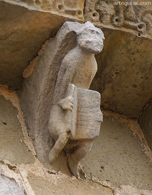 Canecillo con un hombre llevando un libro abierto