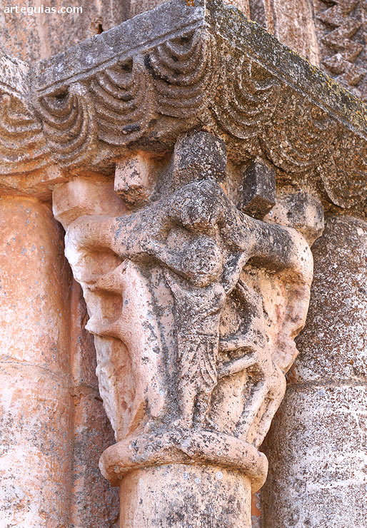 Capitel de la puerta con varios leones y una figura humana